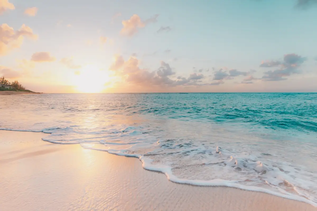 Golden sunrise over a Puerto Rico beach with gentle waves and turquoise Caribbean water — the ideal conditions for a morning snorkeling session in Puerto Rico